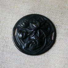 Vannliljemedaljong i svart metallrelieff med sidebånd 