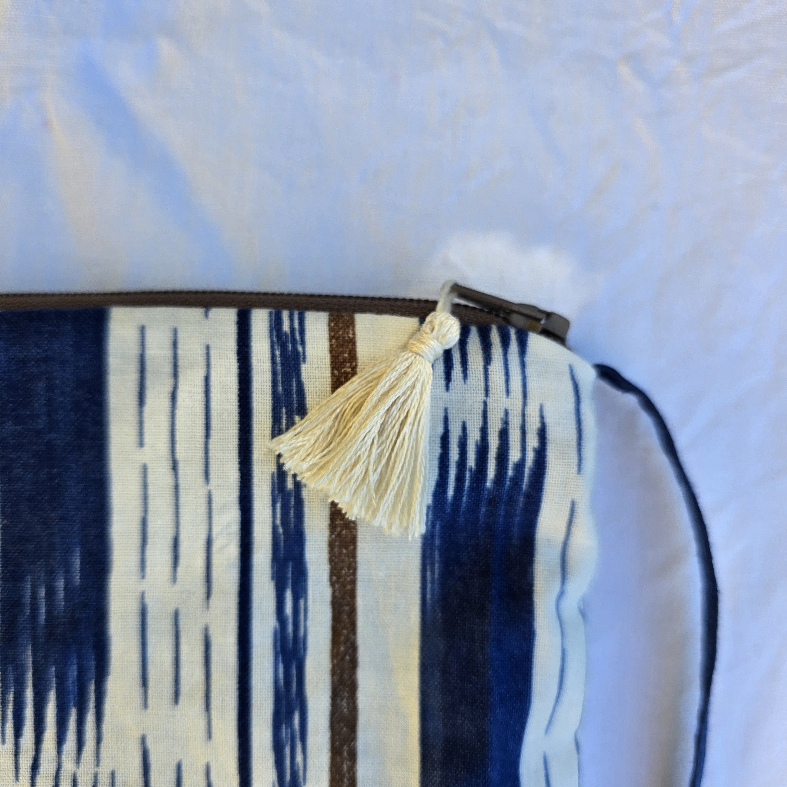 Pochette avec bandouli&egrave;re en tissu coton bleu et marron agr&eacute;ment&eacute;e d'un pompon