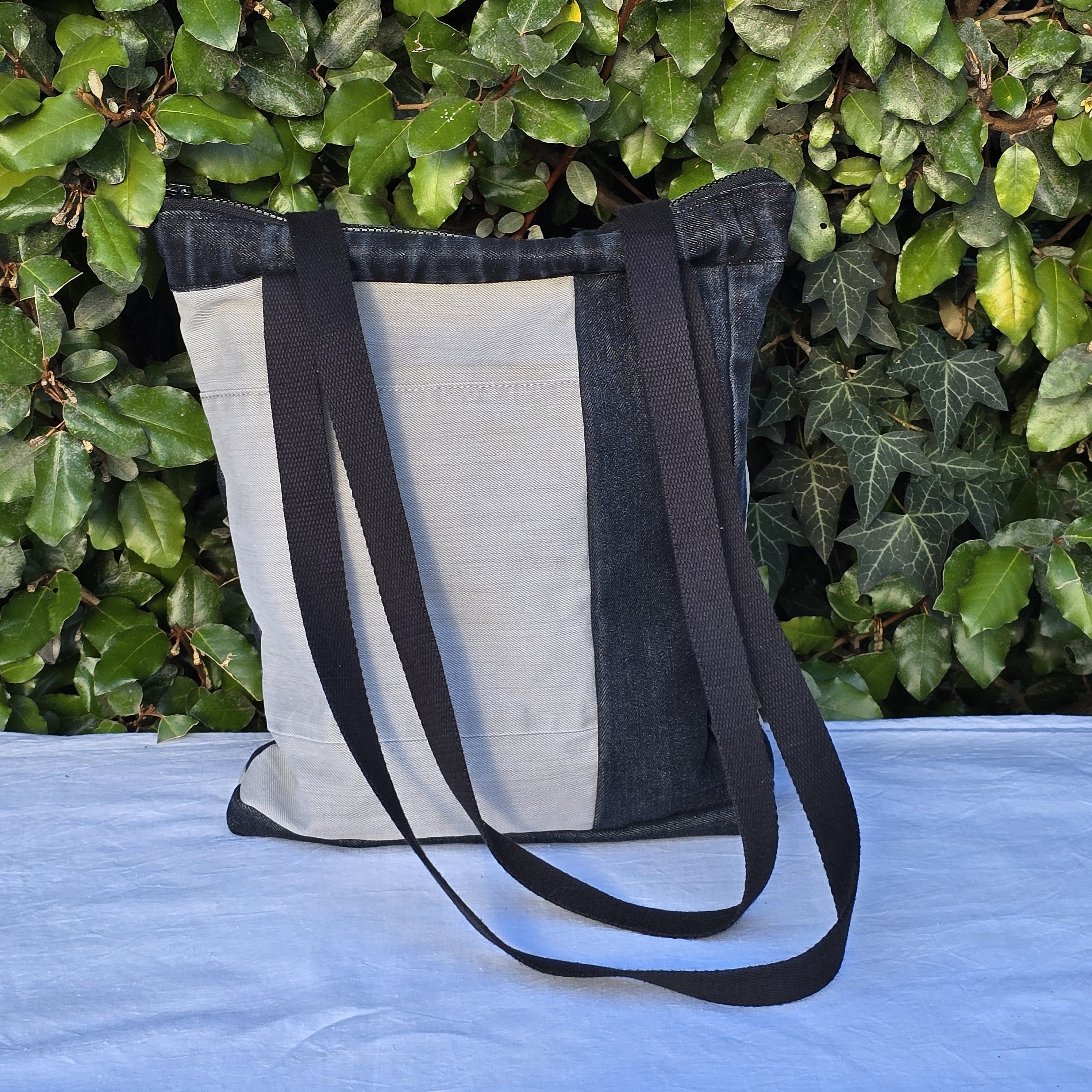 Sac &agrave; bandouli&egrave;re en jean recycl&eacute; noir et gris avec empi&egrave;cements.