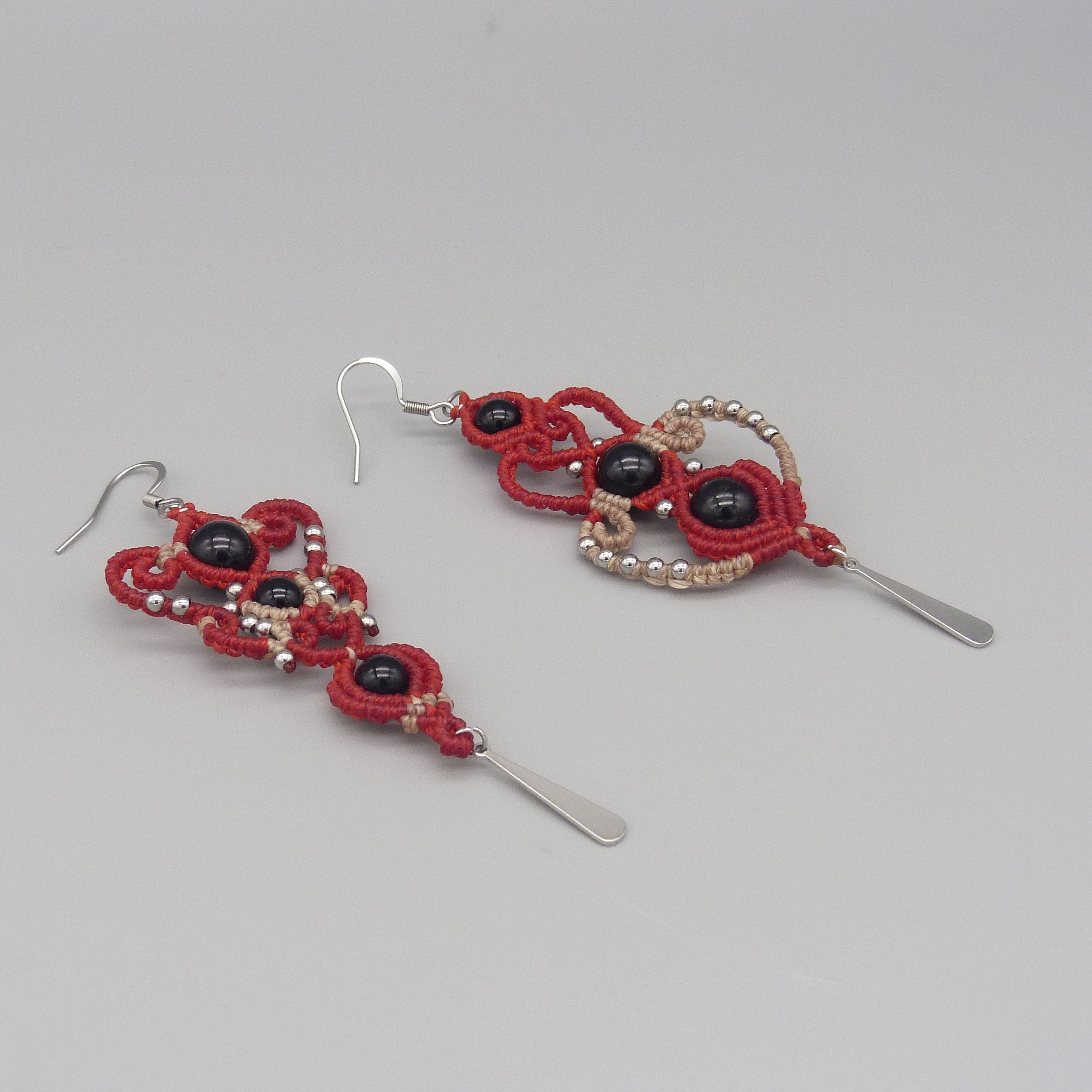 Boucles d'oreilles  en micro-macram&eacute; rouges et beiges avec perles en onyx noir