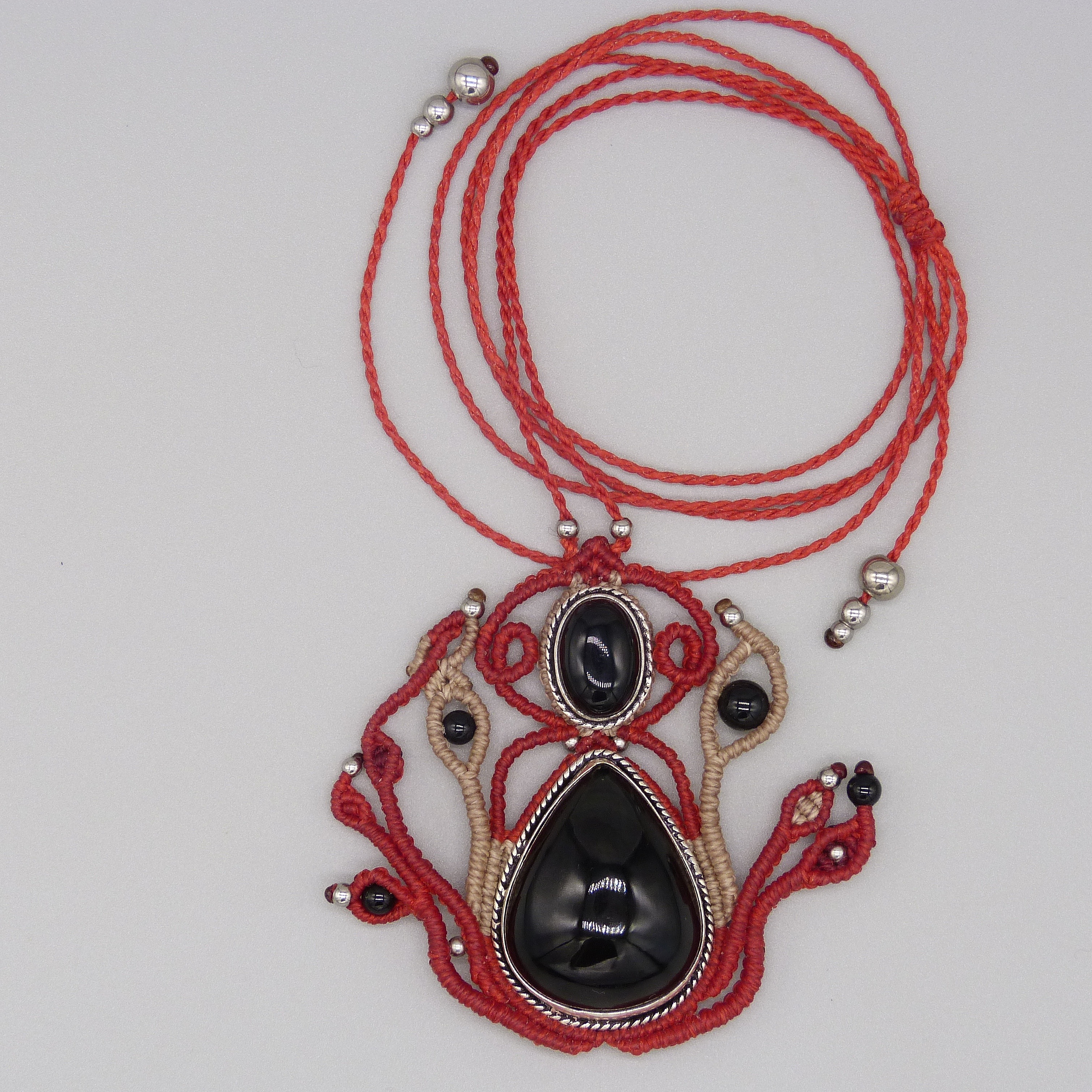 Sautoir en micro-macram&eacute; rouge avec une pierre onyx noire sertie de m&eacute;tal