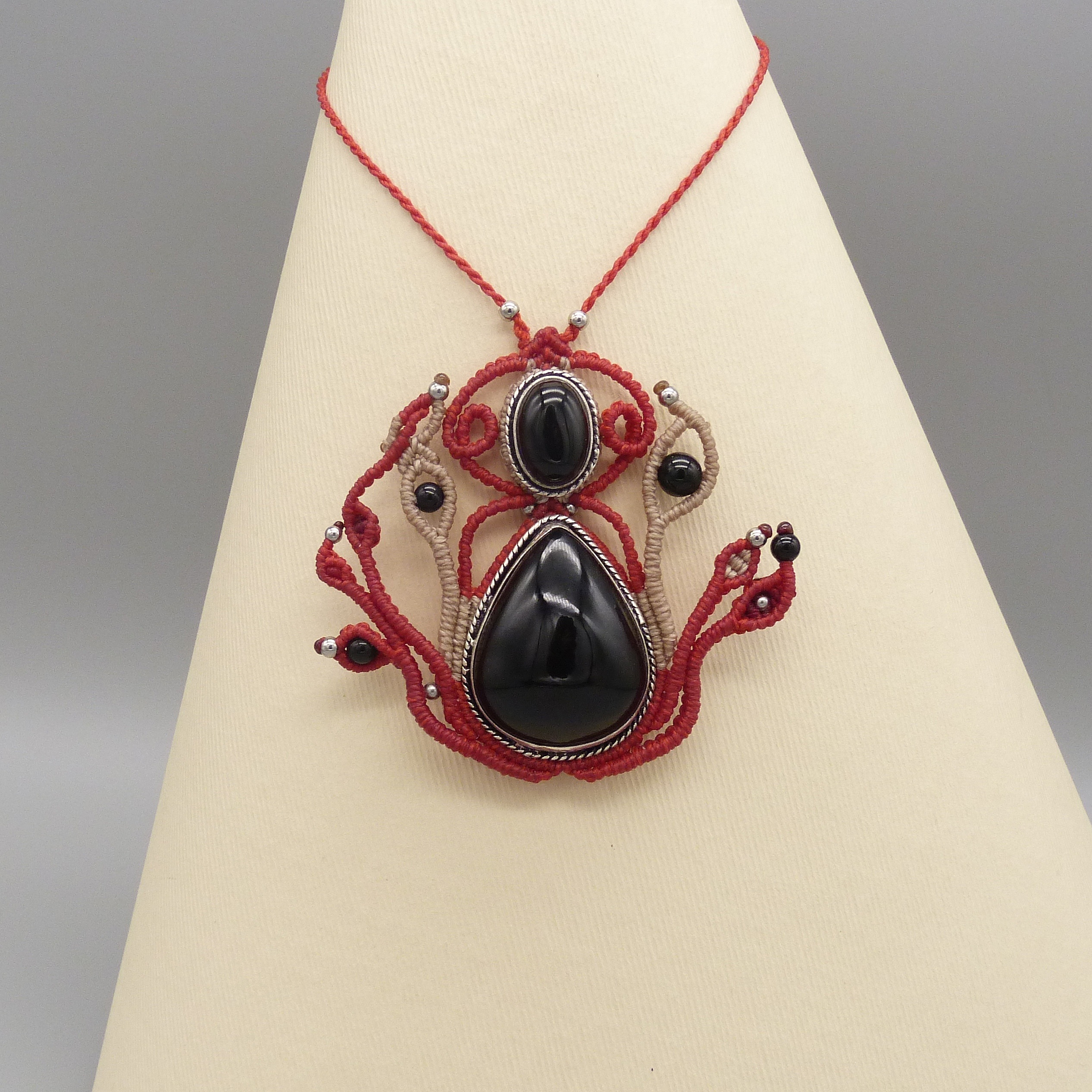 Sautoir en micro-macram&eacute; rouge avec une pierre onyx noire sertie de m&eacute;tal