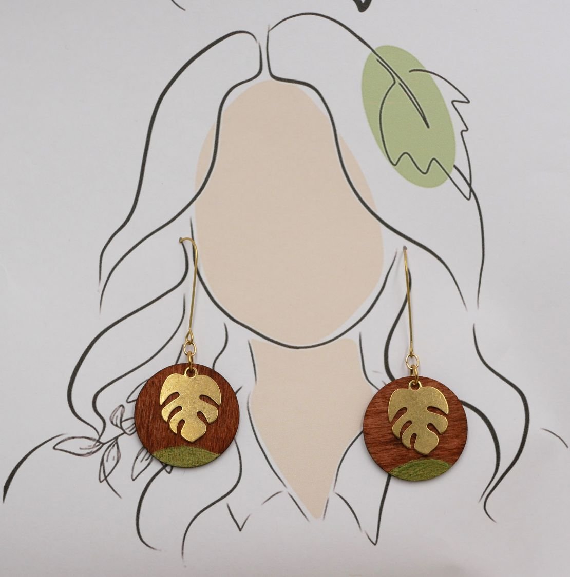 Øredobber laget av kirsebærtre og monstera blad i gullbelagt messing