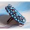 Naïade ring brodert med en turkisblå harpiks og krystall cabochon, et vakkert lysspill.
