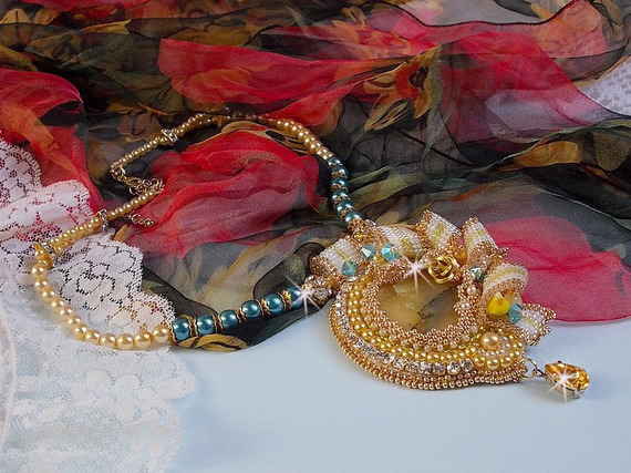 Haute-Couture Sunflower Gold anheng brodert med 24 karat gullbelagte frøperler, en Madagaskar opal og Swarovski krystaller.