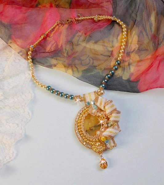 Haute-Couture Sunflower Gold anheng brodert med 24 karat gullbelagte frøperler, en Madagaskar opal og Swarovski krystaller.
