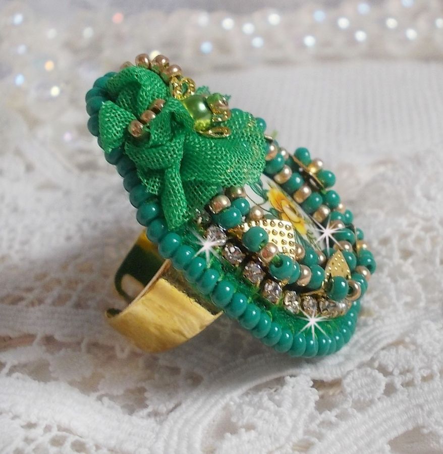 Vakker smaragdring med en keramisk cabochon laget av en gul og grønn rose