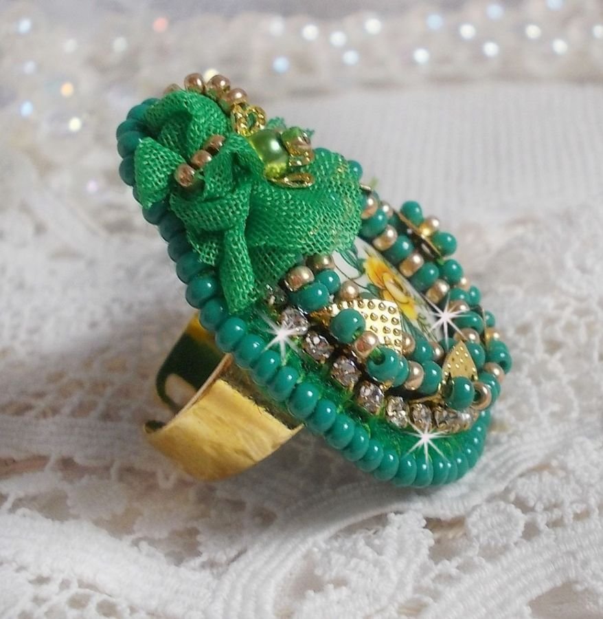 Vakker smaragdring med en keramisk cabochon laget av en gul og grønn rose