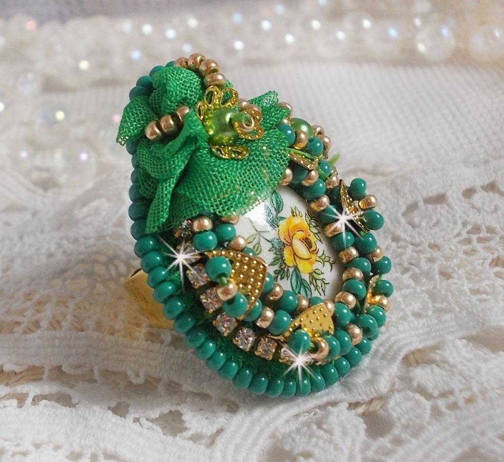 Vakker smaragdring med en keramisk cabochon laget av en gul og grønn rose