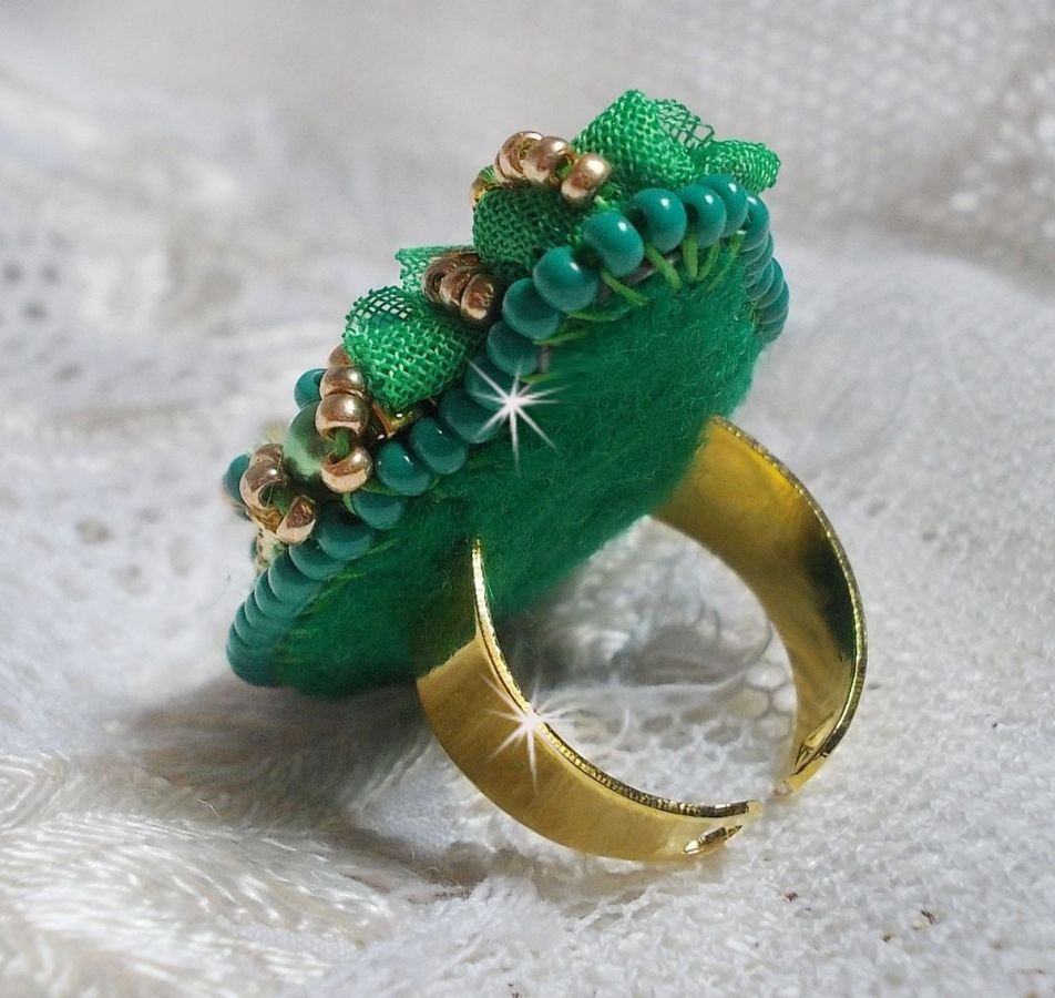 Vakker smaragdring med en keramisk cabochon laget av en gul og grønn rose