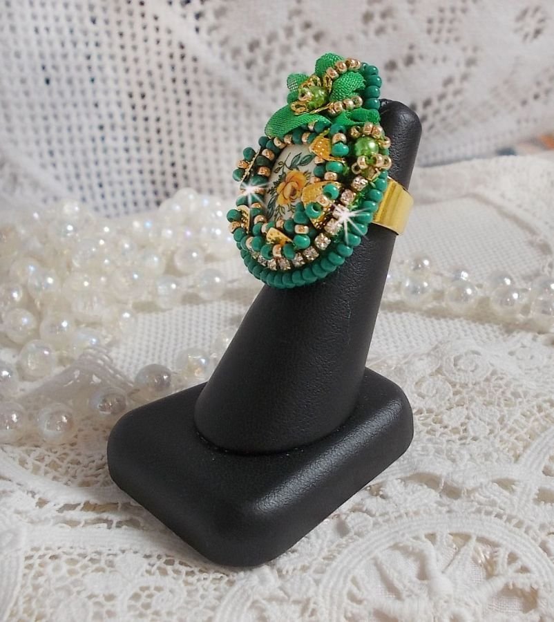 Vakker smaragdring med en keramisk cabochon laget av en gul og grønn rose