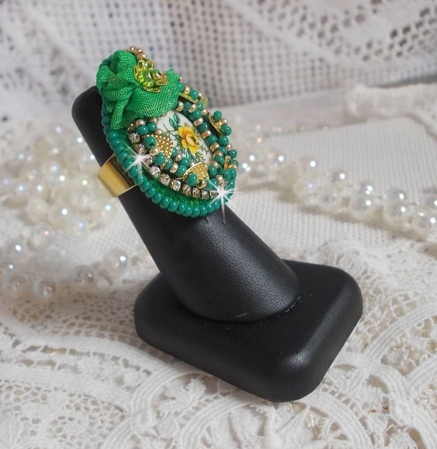 Vakker smaragdring med en keramisk cabochon laget av en gul og grønn rose