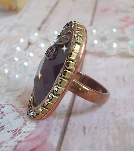 Elegant Burgundy-ring laget med PureCrystal-krystaller, et blomsterformet stempel og en glass cabochon.