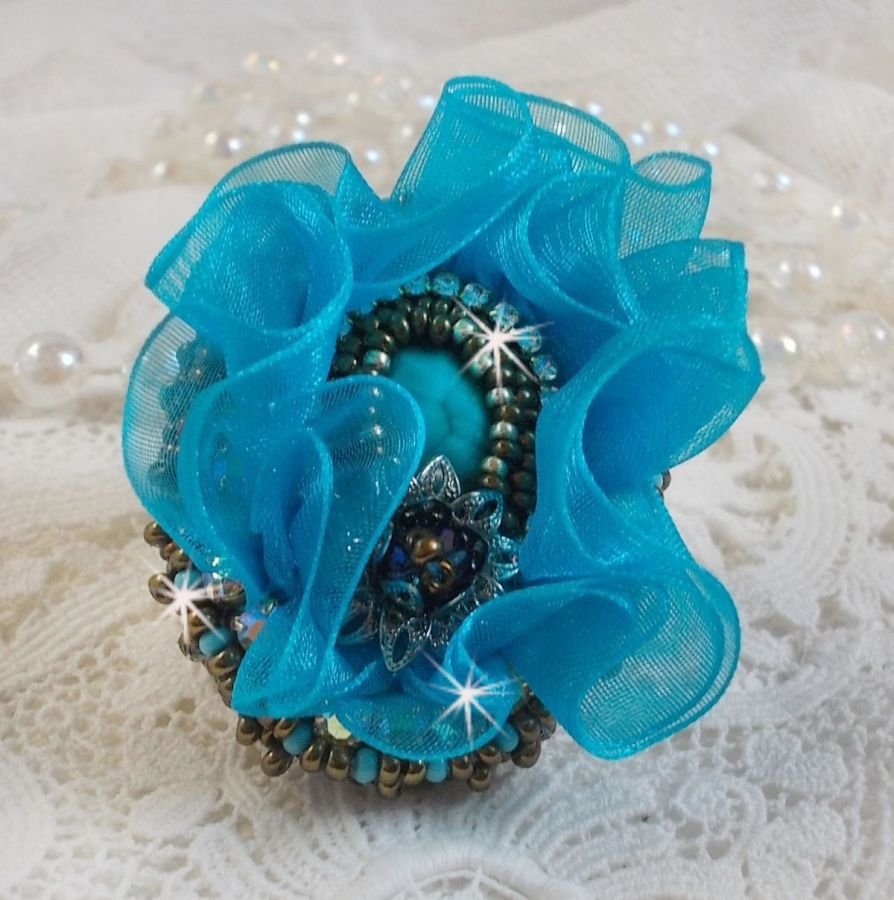 Ilycia sjarmerende ring brodert med en fasettert turkisblå harpiks cabochon og et organzabånd