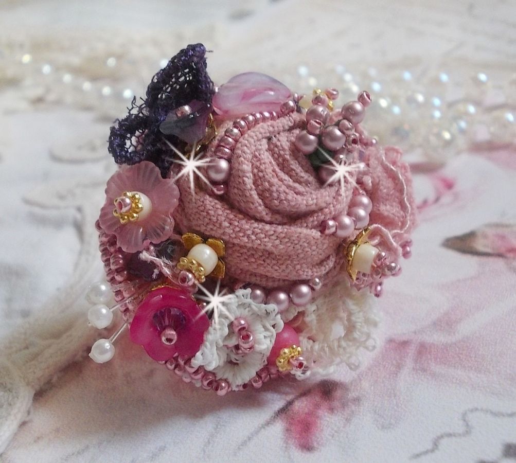 Poetisk hagering brodert med lin, fine blonder, Swarovski-krystaller, perlemorblad, lucitablomster, glassperler og frøperler. 