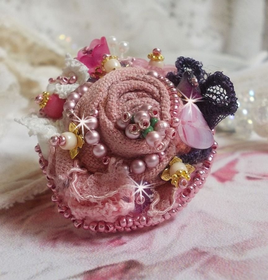 Poetisk hagering brodert med lin, fine blonder, Swarovski-krystaller, perlemorblad, lucitablomster, glassperler og frøperler. 