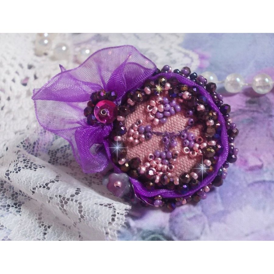 Romantisk Lady Ring brodert på et rosa linstoff med rosa, iris, lilla og fersken frøperler 