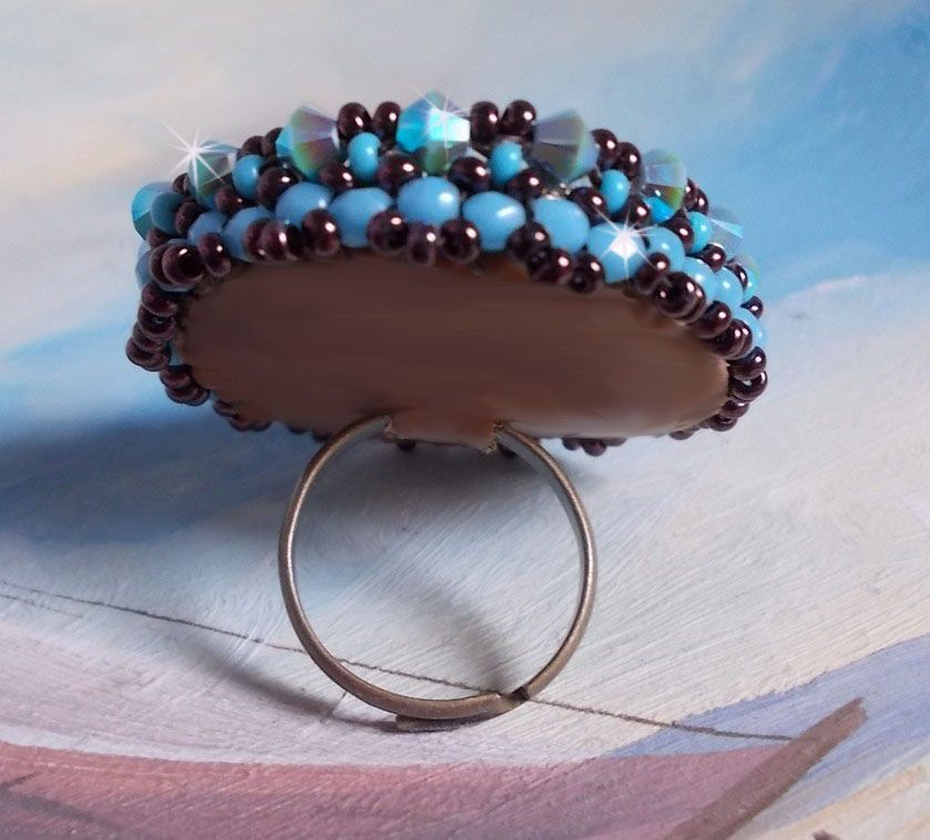 Naïade ring brodert med en turkisblå harpiks og krystall cabochon, et vakkert lysspill.