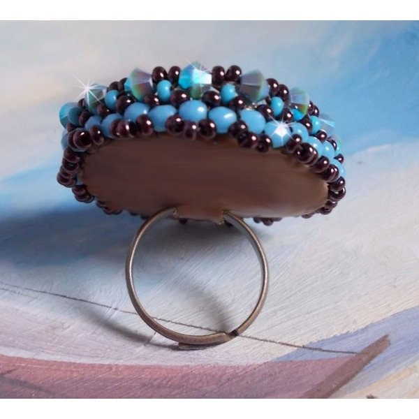Naïade ring brodert med en turkisblå harpiks og krystall cabochon, et vakkert lysspill.