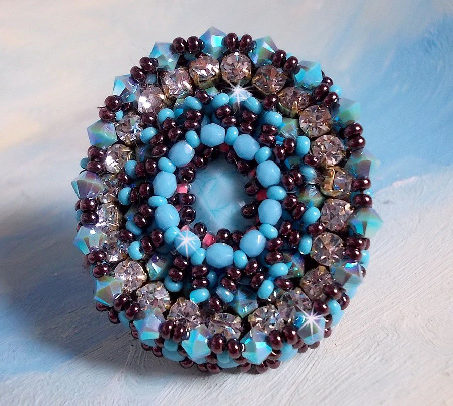 Naïade ring brodert med en turkisblå harpiks og krystall cabochon, et vakkert lysspill.