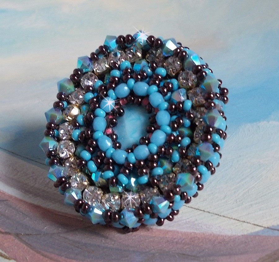 Naïade ring brodert med en turkisblå harpiks og krystall cabochon, et vakkert lysspill.