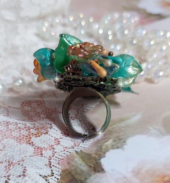 Bague Patiflo d&rsquo;une composition florale cr&eacute;&eacute;e avec des cristaux, fleurs en R&eacute;sine, perles, clochettes, pens&eacute;es, boutons de rose en Verre, estampes et coupelles. Le tout est mont&eacute; sur une bague estampe