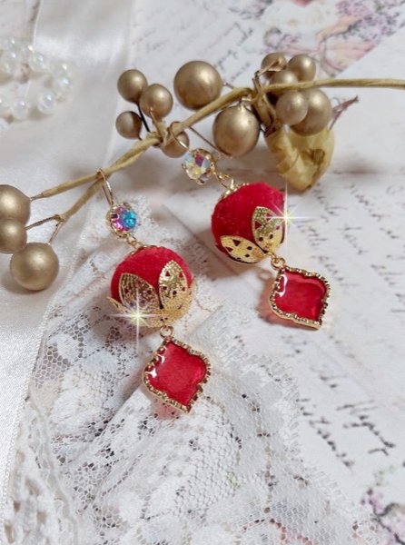 BO Passionn&eacute;ment mont&eacute;es avec des pompons Rouges tr&egrave;s tendances &agrave; laquelle s&rsquo;ajoute des coupelles en forme d&rsquo;arabesque, pendentifs vitrail Rouge/Dor&eacute; et cabochons en Cristal AB sur crochets en Laiton
