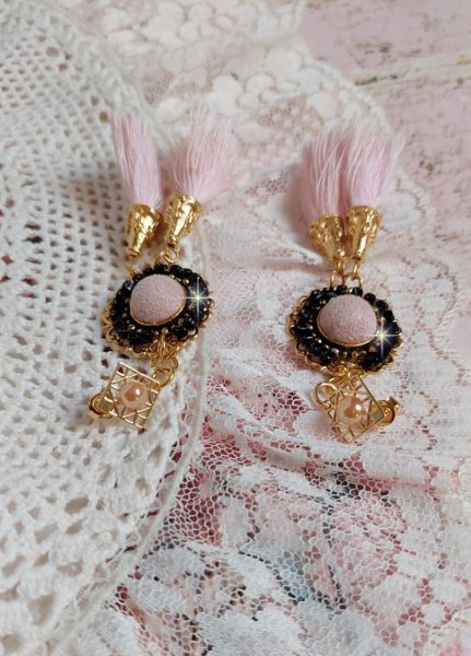 BO Rosy Rose mont&eacute;es avec des cabochons en tissu velours rose poudr&eacute; orn&eacute; d&rsquo;une cha&icirc;ne strass Cristal Noir sur estampes Dor&eacute;es en Laiton. S&rsquo;ajoute des pompons avec c&ocirc;nes M&eacute;tal sur clous en Argent 925