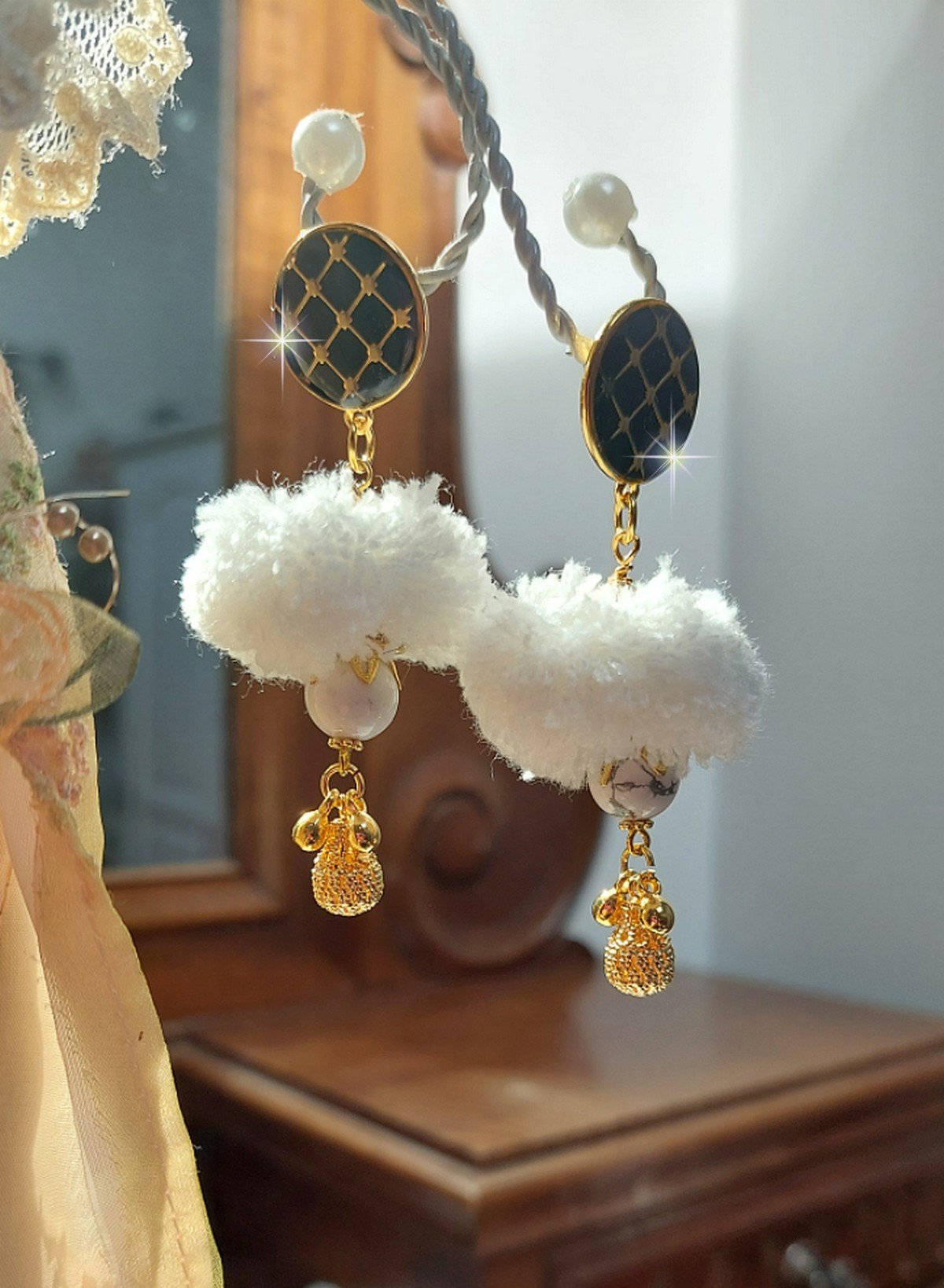 BO Cassandre avec des pierres de gemme : le Howlite Blanc &agrave; laquelle s&rsquo;ajoute des pompons, des intercalaires rondelles, des coupelles feuilles et breloques. Mont&eacute;s sur des puces Noires et Dor&eacute;es 