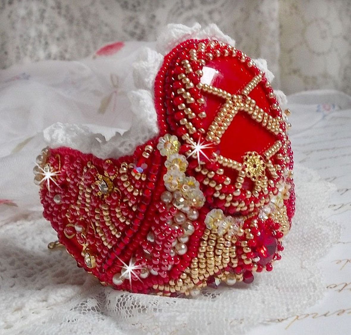 Nous Two Cuff Bracelet Haute-Couture brodert med Swarovski-krystaller, en oval rød glasscabochon og frøperler