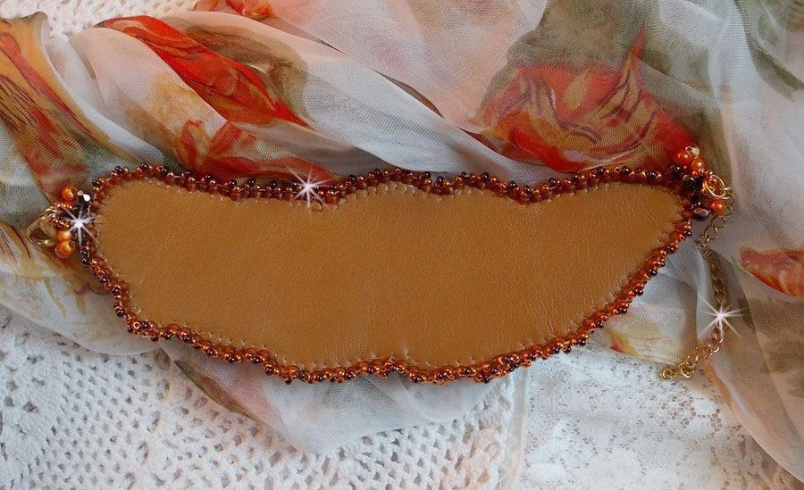 Dame i oransje mansjettarmbånd Haute-Couture brodert med Swarovski-krystaller og Miyuki frøperler.