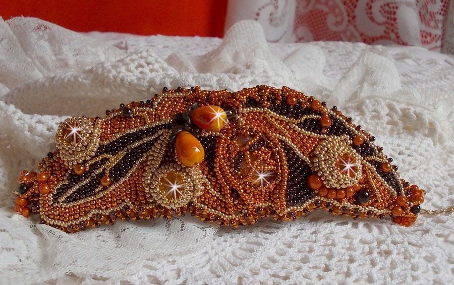 Dame i oransje mansjettarmbånd Haute-Couture brodert med Swarovski-krystaller og Miyuki frøperler.