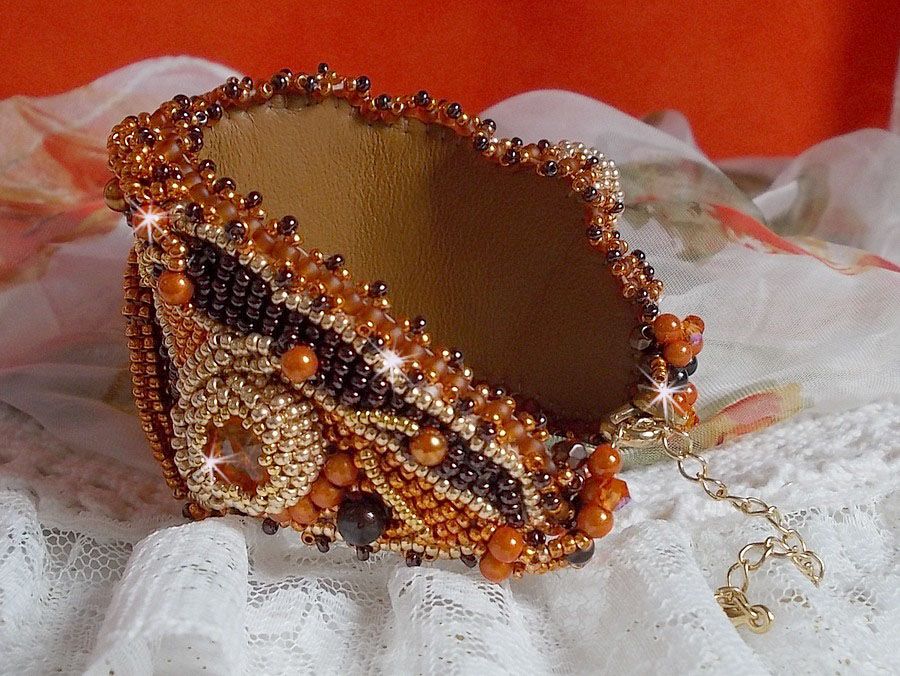 Dame i oransje mansjettarmbånd Haute-Couture brodert med Swarovski-krystaller og Miyuki frøperler.