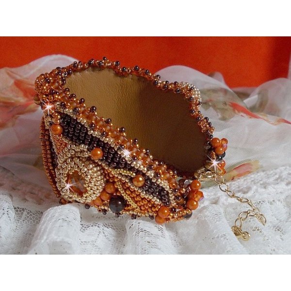 Dame i oransje mansjettarmbånd Haute-Couture brodert med Swarovski-krystaller og Miyuki frøperler.