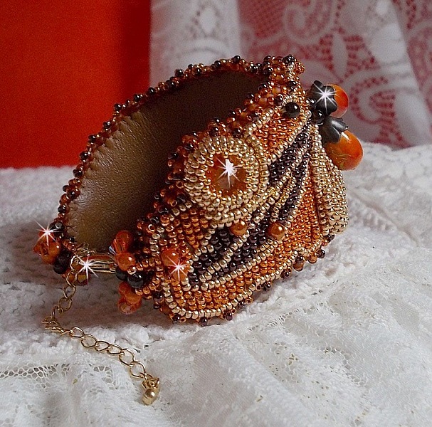 Dame i oransje mansjettarmb&aring;nd Haute-Couture brodert med Swarovski-krystaller og Miyuki fr&oslash;perler.