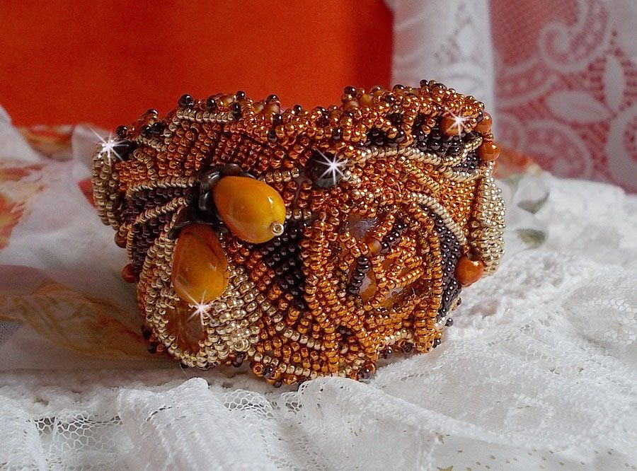 Dame i oransje mansjettarmbånd Haute-Couture brodert med Swarovski-krystaller og Miyuki frøperler.