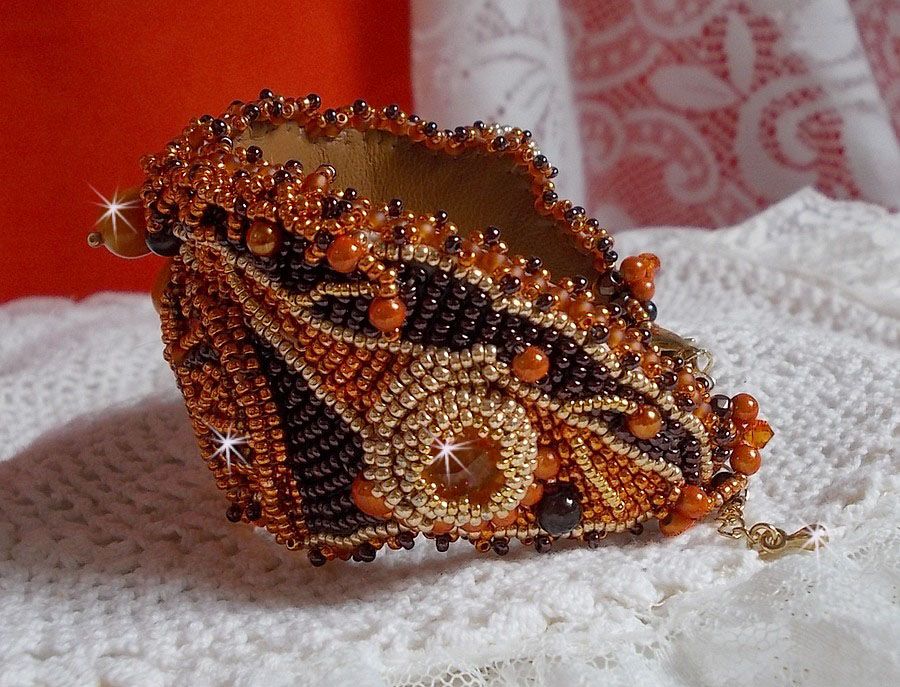 Dame i oransje mansjettarmbånd Haute-Couture brodert med Swarovski-krystaller og Miyuki frøperler.