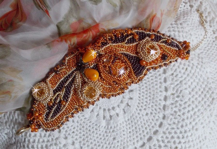 Dame i oransje mansjettarmbånd Haute-Couture brodert med Swarovski-krystaller og Miyuki frøperler.