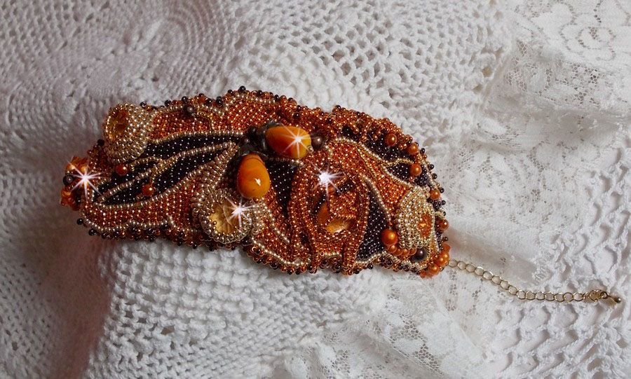 Dame i oransje mansjettarmbånd Haute-Couture brodert med Swarovski-krystaller og Miyuki frøperler.