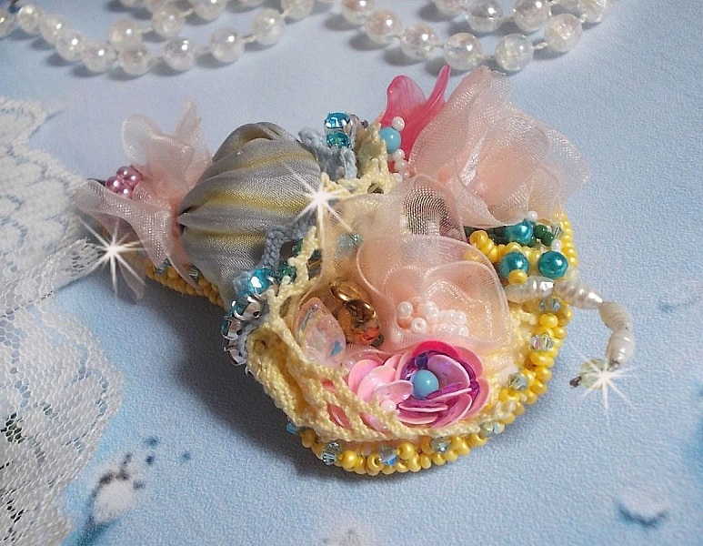 Blomsterparaplybrosje brodert med gr&aring;/gult silkeb&aring;nd, Swarovski-krystaller, Lucite-blomster, perlemorperler, blonder og fr&oslash;perler.