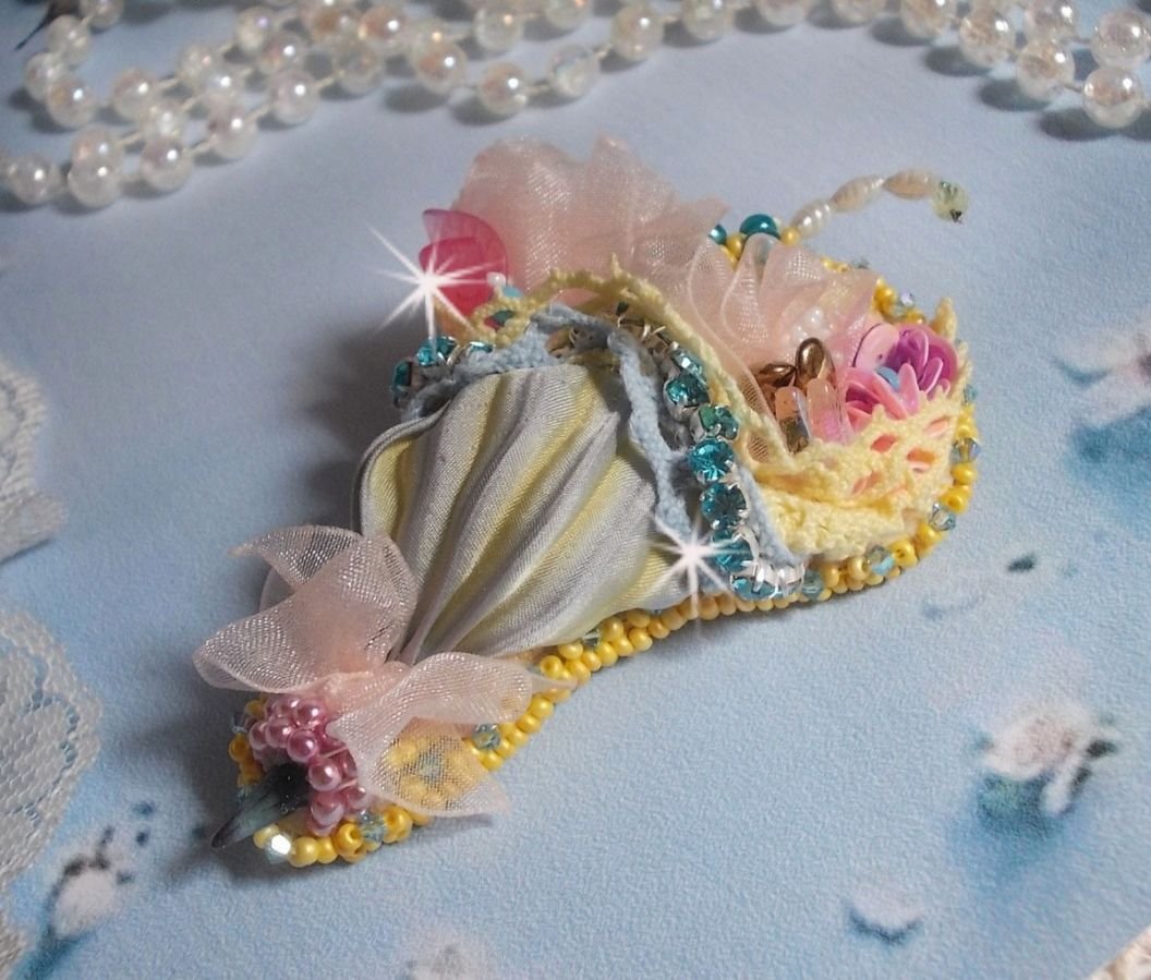Blomsterparaplybrosje brodert med grå/gult silkebånd, Swarovski-krystaller, Lucite-blomster, perlemorperler, blonder og frøperler.