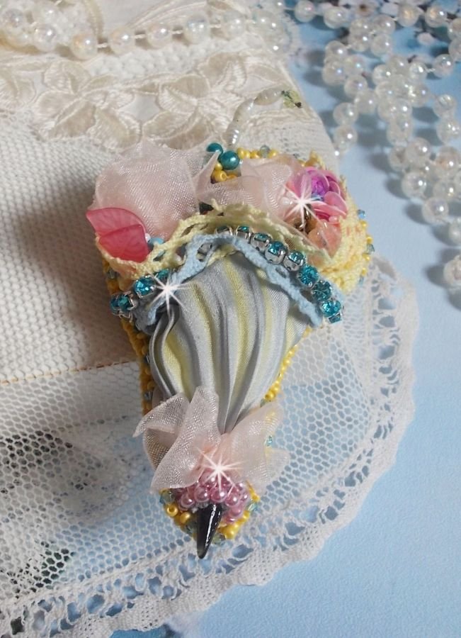 Blomsterparaplybrosje brodert med grå/gult silkebånd, Swarovski-krystaller, Lucite-blomster, perlemorperler, blonder og frøperler.