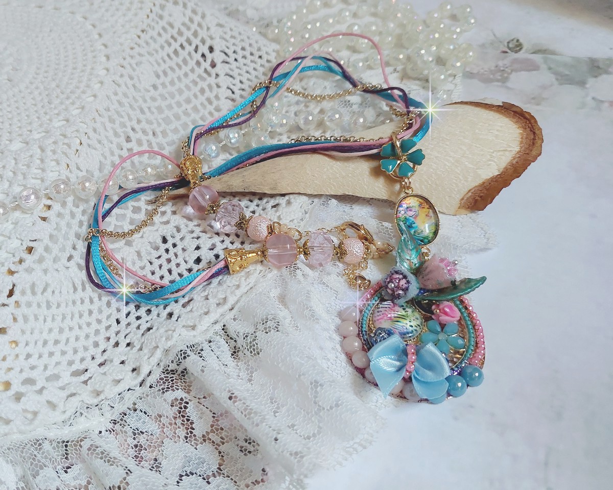  Collier Coquette créé avec deux estampes à laquelle s’ajoute des fleurs en velours floqué, perles aplaties Cristal, fleurs : Epoxy, Porcelaine, Résine, cabochon loupe, rubans et chaîne plaqué Or