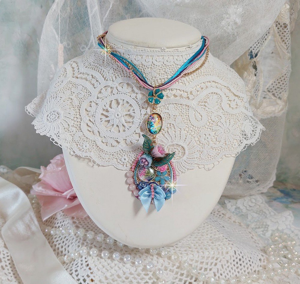  Collier Coquette créé avec deux estampes à laquelle s’ajoute des fleurs en velours floqué, perles aplaties Cristal, fleurs : Epoxy, Porcelaine, Résine, cabochon loupe, rubans et chaîne plaqué Or