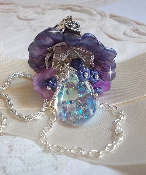 Pendentif Eclat de Cristal mont&eacute; avec une goutte en Cristal, fleurs en Verre, fleurs lucites dont une plus grande peinte &agrave; la main avec paillettes Argent&eacute;es. Une composition florale