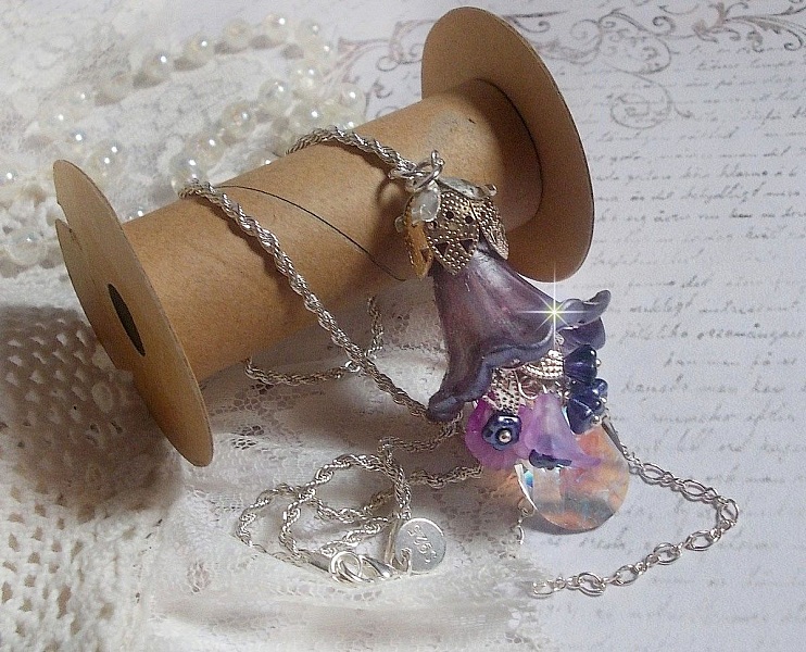 Pendentif Eclat de Cristal mont&eacute; avec une goutte en Cristal, fleurs en Verre, fleurs lucites dont une plus grande peinte &agrave; la main avec paillettes Argent&eacute;es. Une composition florale