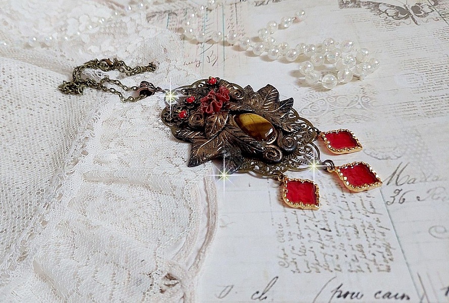 Pendentif M&eacute;lodie avec un cabochon &OElig;il de tigre orn&eacute; de perles en Jade Rouge vein&eacute; de Noir sur fleurs 5 p&eacute;tales et estampes mont&eacute;s sur une cha&icirc;ne bronze. Les pendants sont en r&eacute;sine &eacute;poxy Rouge