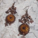 BO Mystères d'Arsène skapt med forskjellige formede charms, anhengsmedaljonger, patinerte porselensmotiver og Swarovski-krystaller.