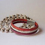 Flettet mansjettarmbånd i hvitt og korallfarget skinn