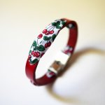 Florâme-armbånd med bånd av kirsebærfrukter på rødt skinn
